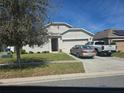 View of the home's exterior, featuring a well-maintained lawn and a two-car garage with driveway at 320 Aberdeen Dr, Davenport, FL 33896