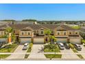 Aerial view of townhomes boasting manicured landscaping, ample parking, and well-maintained exteriors under a clear blue sky at 3610 Rodrick Cir, Orlando, FL 32824