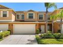 Charming two-story townhome showcasing a two-car garage, neat landscaping, and a welcoming front entrance at 3610 Rodrick Cir, Orlando, FL 32824