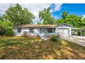 Charming single-story home featuring a well-maintained lawn, covered garage, and quaint front entrance at 412 Noya Ln, Apopka, FL 32712