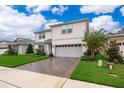Charming two-story home boasts manicured lawn, brick-paved driveway, and a two-car garage at 5414 Log Grove Ln, Orlando, FL 32829