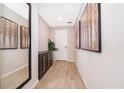Bright foyer features wood-look floors, mirror and art, leading to the front door at 5414 Log Grove Ln, Orlando, FL 32829