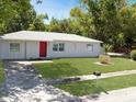 Charming one-story home with well-maintained lawn and a bright red front door at 5464 Windridge Ln, Orlando, FL 32810