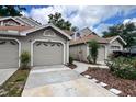 Exterior view of townhomes with attached garages and landscaping under a blue sky at 554 Northbridge Dr, Altamonte Springs, FL 32714