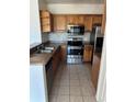 Kitchen featuring stainless steel appliances, wood cabinets, and tile backsplash at 6141 Metrowest Blvd # 303, Orlando, FL 32835