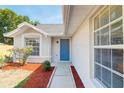 Home featuring a bright blue front door and well maintained landscape at 6593 Meritmoor Cir, Orlando, FL 32818
