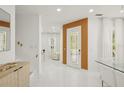 Bright Foyer featuring white tile flooring, wood accent wall, and plenty of natural light at 6632 Pasturelands Pl, Winter Garden, FL 34787