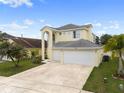 Charming two-story home featuring a three-car garage, lush lawn and palm trees at 6714 Bouganvillea Crescent Dr, Orlando, FL 32809