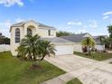Elegant home showcasing a three-car garage, expansive driveway, and mature landscaping at 6714 Bouganvillea Crescent Dr, Orlando, FL 32809