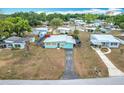 Charming single story home featuring a tidy front yard, paved driveway, and unique sky blue exterior at 690 W Pearl St, Bartow, FL 33830