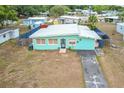 Charming single story home featuring a tidy front yard, paved driveway, and unique sky blue exterior at 690 W Pearl St, Bartow, FL 33830