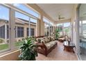 Relaxing sunroom with tile floors, ceiling fan, and large windows offering views of the backyard at 801 Ashton Dr, Davenport, FL 33837