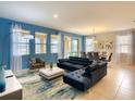 Open-concept living and dining area with stylish furnishings and plenty of natural light from large windows and sliding glass doors at 8039 Oak Shadow Ct, Davenport, FL 33837