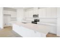 Bright kitchen featuring an island, stainless steel appliances, and white cabinets at 816 Lake Dell Rd, Dundee, FL 33838