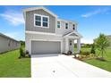 Stylish two-story home featuring gray exterior, a well-manicured lawn and concrete driveway at 824 Lake Dell Rd, Dundee, FL 33838