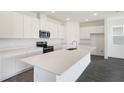 Bright, modern kitchen featuring white cabinets, an island, and stainless steel appliances at 824 Lake Dell Rd, Dundee, FL 33838