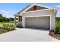 A single-Gathering home featuring a two-car garage, landscaped front yard, and a modern architectural design at 832 Lake Dell Rd, Dundee, FL 33838