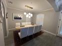 Elegant dining room with modern lighting, seating for six, and window with plantation shutters at 9803 Sweetleaf St, Orlando, FL 32827