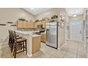 Bright kitchen features stainless appliances, breakfast bar, decorative tile backsplash, and neutral color palette at 1150 Jade East Ln, Kissimmee, FL 34744