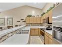 Kitchen boasts stainless appliances, tile backsplash, counter seating, and light wood cabinetry at 1150 Jade East Ln, Kissimmee, FL 34744