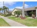 Landscaped front yard with palm trees and view of a screened in porch at 127 Club Villas Ln, Kissimmee, FL 34744