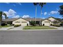 Charming villa-style home with a well-maintained lawn and a beige exterior at 127 Club Villas Ln, Kissimmee, FL 34744