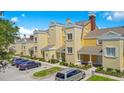 Eye-catching exterior of a multi-unit townhouse with yellow and beige facade, showcasing a well-kept community at 1311 Seven Eagles Ct # 202, Reunion, FL 34747