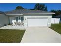 Charming single-story home featuring a two-car garage, modern exterior lighting, and a well-manicured lawn at 15954 Sw 55Th Avenue Rd, Ocala, FL 34473