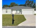 Charming single-story home featuring a two-car garage, modern exterior lighting, and a well-manicured lawn at 15954 Sw 55Th Avenue Rd, Ocala, FL 34473
