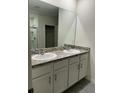 Bathroom featuring a double vanity with a granite countertop, white cabinetry, and a large mirror at 167 Eagleview Loop, Davenport, FL 33837