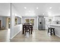 Open layout with the kitchen in background with white cabinets, stainless appliances, and dining area at 18806 Monroe Ave, Orlando, FL 32820