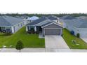 Well-maintained one-story home with a gray exterior, tidy landscaping, and a two-car garage, offering a welcoming facade at 2059 Dexter St, Haines City, FL 33844