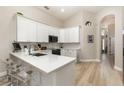 Bright kitchen featuring white cabinets, stainless steel appliances, and a quartz countertop island at 2735 Lido Key Dr, Kissimmee, FL 34747