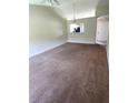 Spacious living room with neutral walls, carpet flooring, and an open view to the kitchen at 2781 King Oak Cir, St Cloud, FL 34769