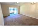 Bright living room featuring a ceiling fan, neutral walls, and sliding glass doors to a screened lanai at 2781 King Oak Cir, St Cloud, FL 34769