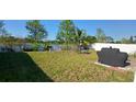 Spacious backyard featuring a well-maintained lawn, privacy fence, patio area, and outdoor seating at 2950 Scarlett Dr, St Cloud, FL 34772