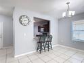 Bright dining area features tile floors, a modern chandelier, and a pass-through to the kitchen at 3105 Sangria St, Kissimmee, FL 34744