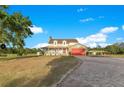 Stunning two-story home boasts a charming front porch, red garage door, and brick-paved driveway at 3255 Tucker Ave, St Cloud, FL 34772