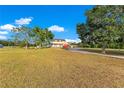 Expansive front yard showcasing a charming home with a covered porch and attached garage at 3255 Tucker Ave, St Cloud, FL 34772