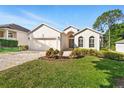 Beautiful one-story home features a paver driveway and meticulously landscaped front yard at 3421 Capland Ave, Clermont, FL 34711
