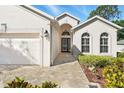 Close-up of front entrance featuring pavers, arched windows, and a black front door at 3421 Capland Ave, Clermont, FL 34711