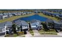 Overhead view of modern homes surrounding a scenic pond, creating a tranquil community setting at 345 Ocean Course Ave, Davenport, FL 33896