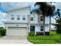 Contemporary two-story home featuring stone accents, a two-car garage, and a well-manicured lawn at 345 Ocean Course Ave, Davenport, FL 33896
