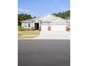 A single-Gathering home with a two-car garage and stone accents on a sunny day at 348 Conway Ave, St Cloud, FL 34771