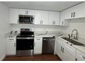 Well-lit kitchen with stainless steel appliances, quartz countertops, white cabinets and sleek hardware at 3815 Nw Avenue R Ave, Winter Haven, FL 33881