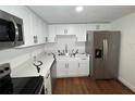 Bright kitchen featuring stainless steel appliances, quartz countertops, white cabinets, and wood-look floors at 3815 Nw Avenue R Ave, Winter Haven, FL 33881