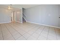 Bright living room with neutral tones, tile floors, and a view of the staircase, ideal for relaxation and entertaining guests at 4215 S Semoran Blvd # 15, Orlando, FL 32822