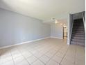 Spacious living area with tile flooring and staircase, offering a blank canvas for personalization and comfortable living at 4215 S Semoran Blvd # 15, Orlando, FL 32822