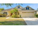 Charming home featuring a well-maintained lawn, mature landscaping, and a welcoming two-car garage at 506 Alleria Ct, Auburndale, FL 33823