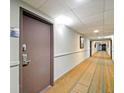 Hallway with neutral carpet, light walls, and the door of unit 1603 at 6165 Carrier Dr # 1603, Orlando, FL 32819